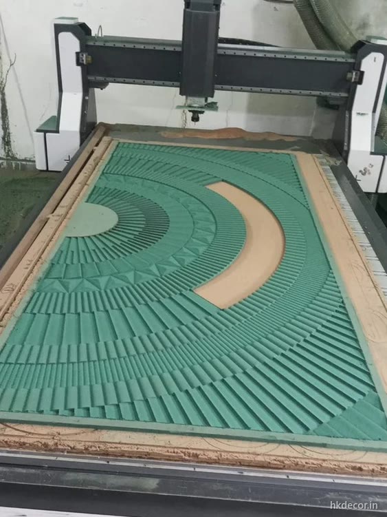 CNC router part way through cutting a radial pattern panel on the bed